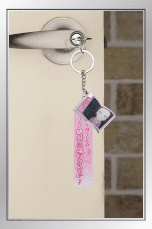 Nezuko Kamado Demon Slayer keychain with quote tag and portrait charm hanging on door handle