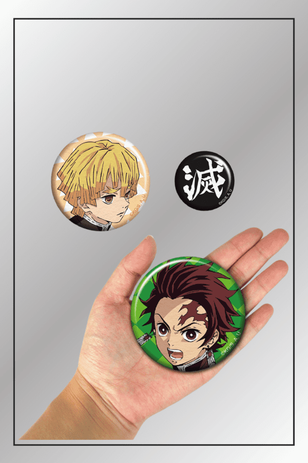 Demon Slayer badge set with Tanjiro Kamado, Zenitsu Agatsuma, and metsu kanji symbol shown with hand for size reference