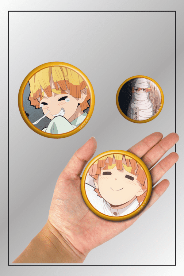 Demon Slayer 3-piece badge pin set featuring Zenitsu Agatsuma and Obanai Iguro with one pin shown in hand for size comparison